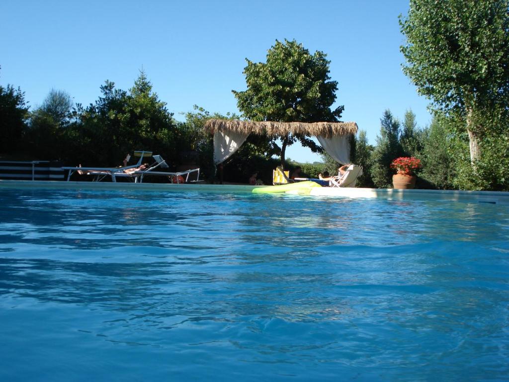 拉迪孔多利Agriturismo Materno的坐在游泳池木筏上的女人