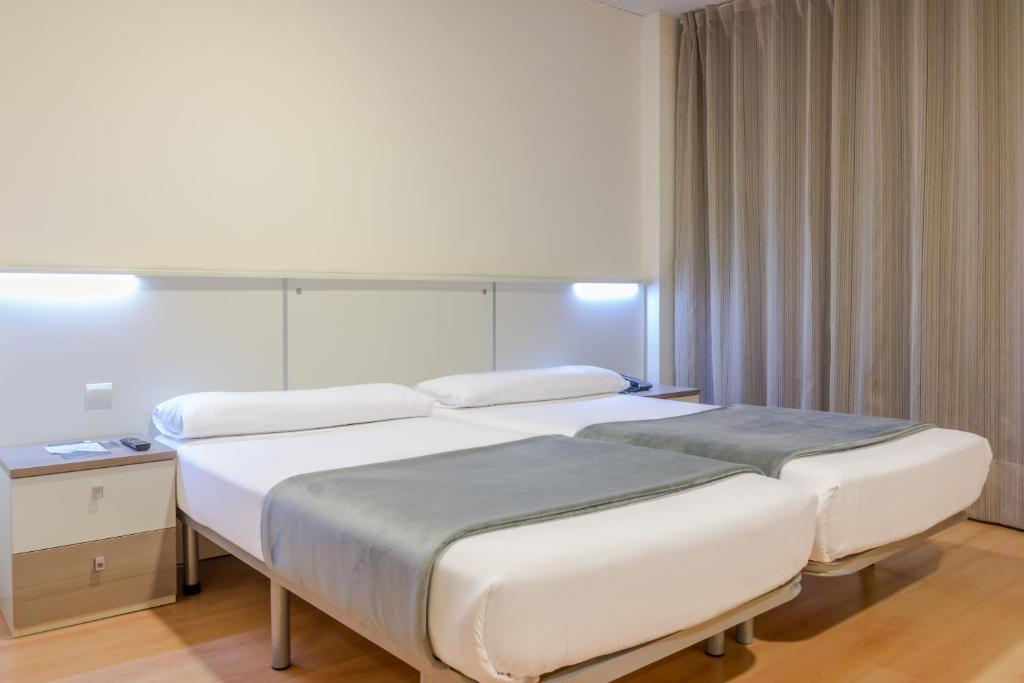 马德里顶点酒店的酒店客房设有两张床和窗户。