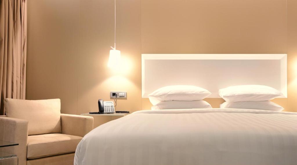 约阿尼纳Saz City Life Boutique Hotel的卧室配有白色的床和椅子