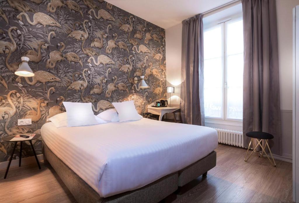 巴黎玛莱斯圣女贞德酒店的一间卧室配有一张带花卉壁纸的大床