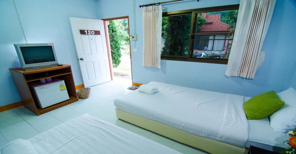 Ban Dong Ma Tun平多伊度假酒店的一间卧室设有一张床、一台电视和一个窗口。