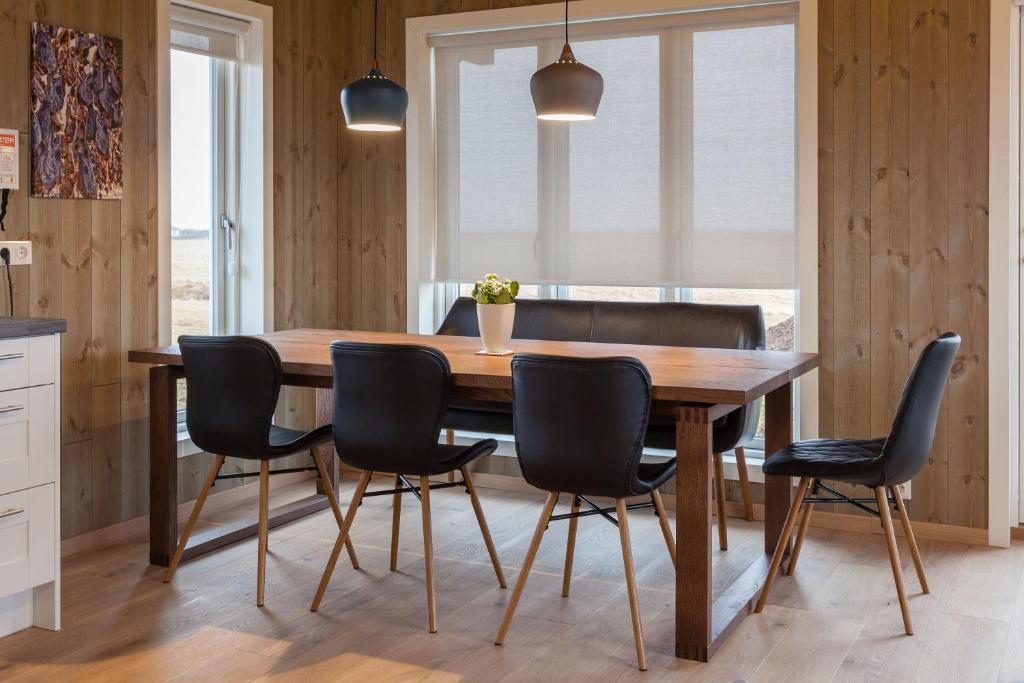 霍尔斯沃德吕尔Kornhóll的一间带木桌和椅子的用餐室
