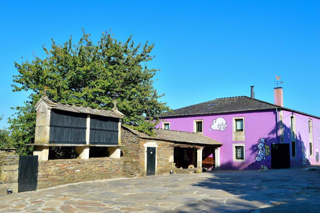 卢戈Casa de Baixo的前面有棵树的粉红色建筑