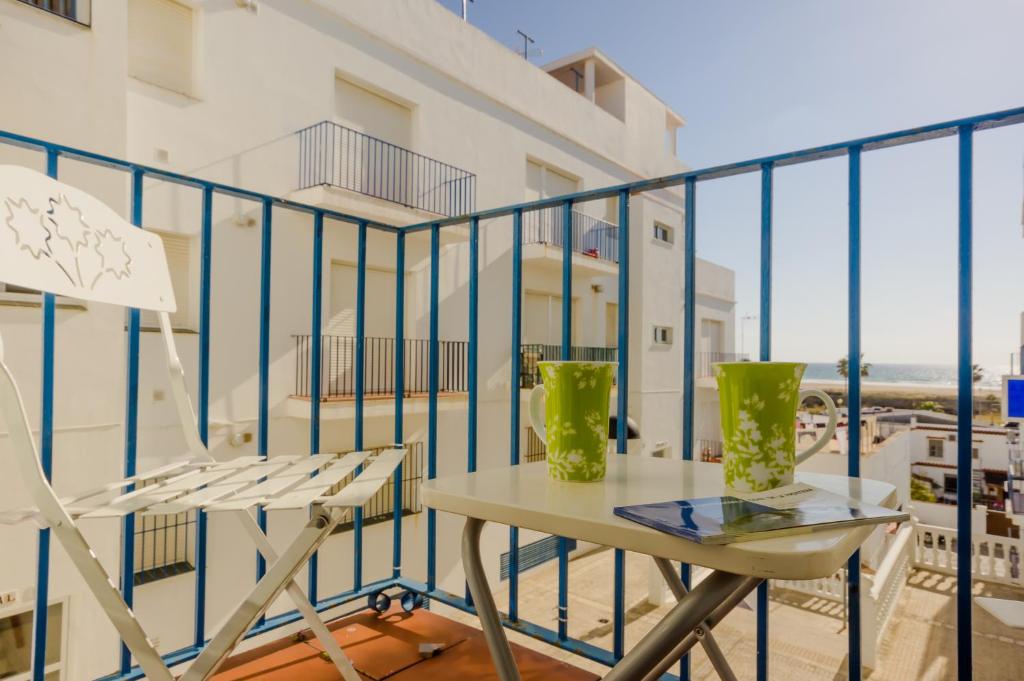 科尼尔-德拉弗龙特拉Apartamentos Carril de la Fuente的阳台配有桌椅,享有海景。