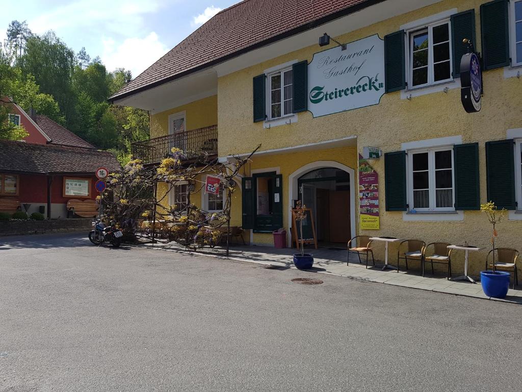 SchwanbergGasthof Restaurant Steirereck'n的一座建筑前面有商店,有椅子