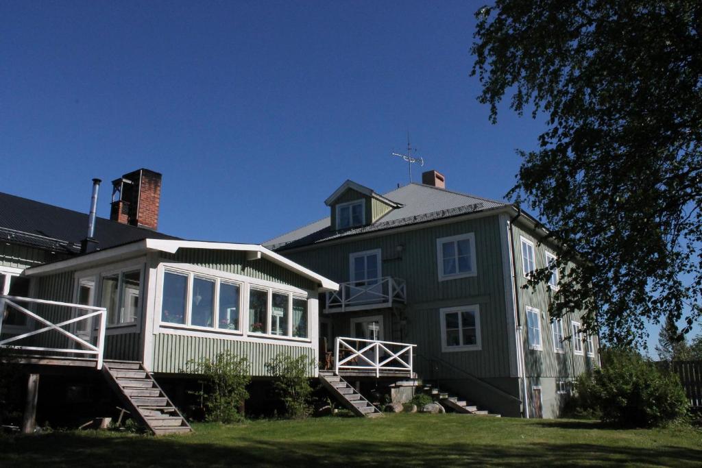 StorseleJärjagården Hostel的一座带楼梯的大型绿色房屋
