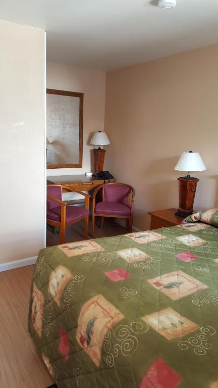 奥里利亚枫树汽车旅馆的酒店客房带一张床、一张桌子和椅子