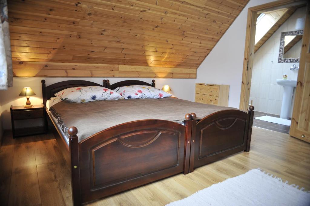 比亚沃维耶扎"Pod Szumiącą Topolą"的木床,位于一个拥有木制天花板的房间
