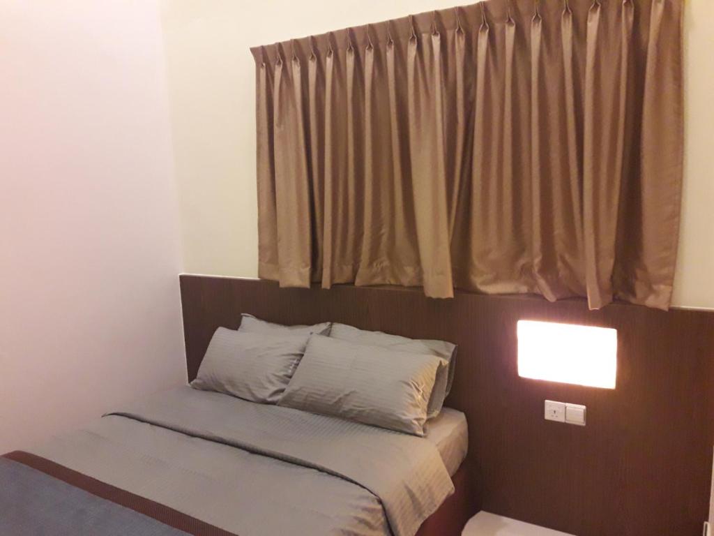 马六甲德奔驰酒店 的窗户客房内的小床