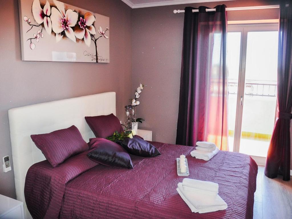 菲乌米奇诺艾拉斯别墅的一间卧室配有一张带枕头的紫色床和窗户。