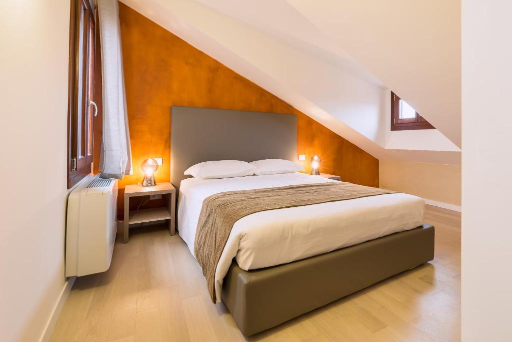 威尼斯查明帕莱斯科特德尔帝特洛公寓的阁楼上的卧室配有一张大床