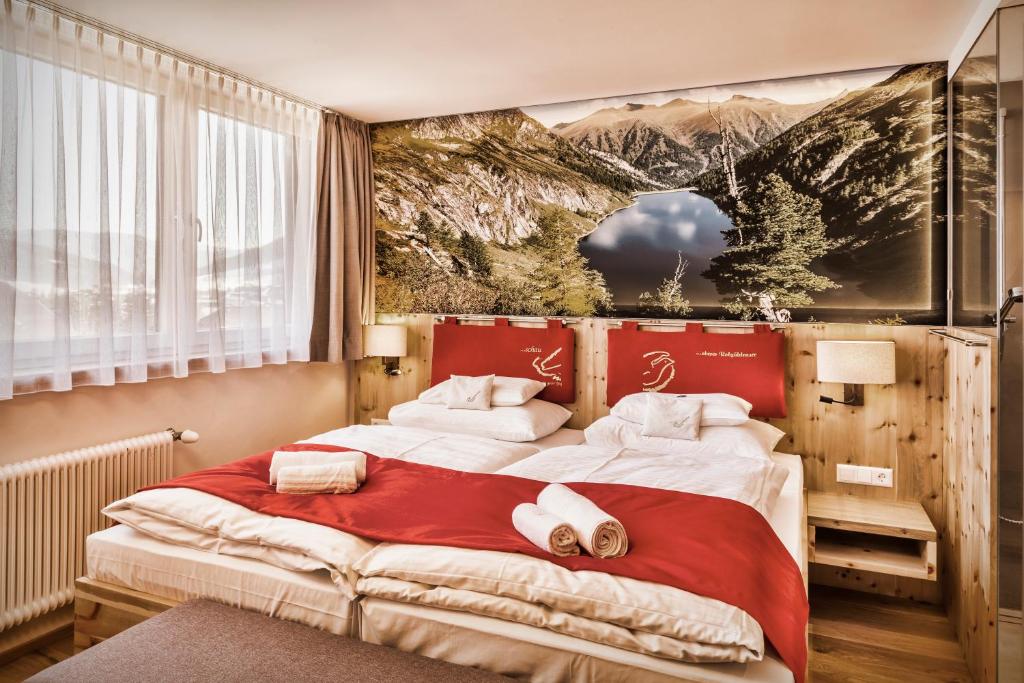 毛特恩多夫schaus Lüftenegger - Apart-Zirbenpension的一间卧室配有一张大床和毛巾