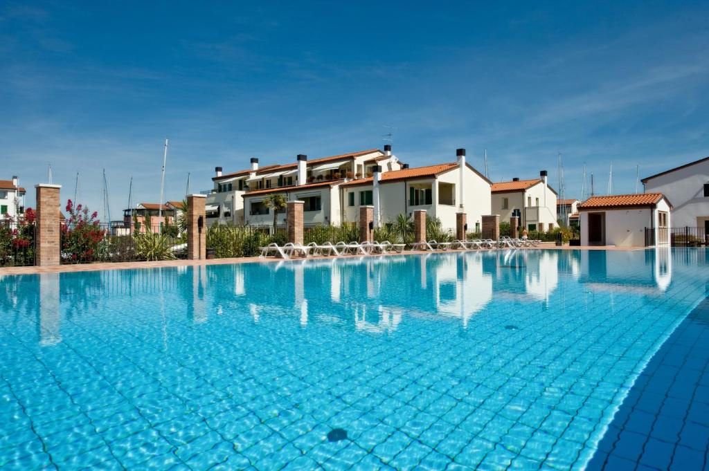 卡奥莱Residence Maestrale的一座大型蓝色游泳池,其背景是房屋