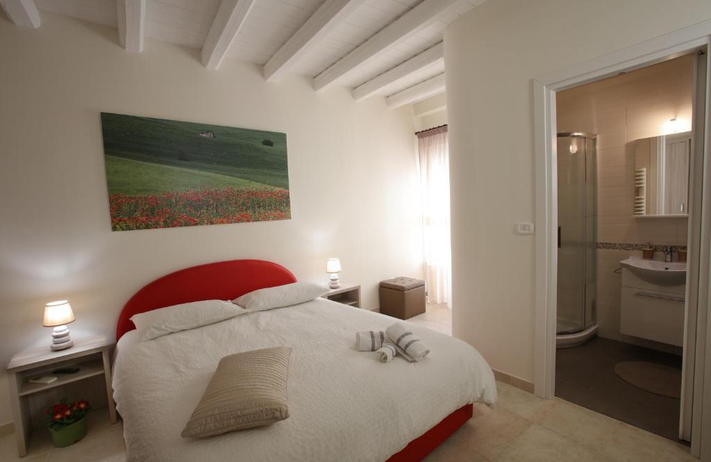 鲁沃迪普利亚B&B Casa Rubis的卧室配有白色的床和墙上的绘画作品