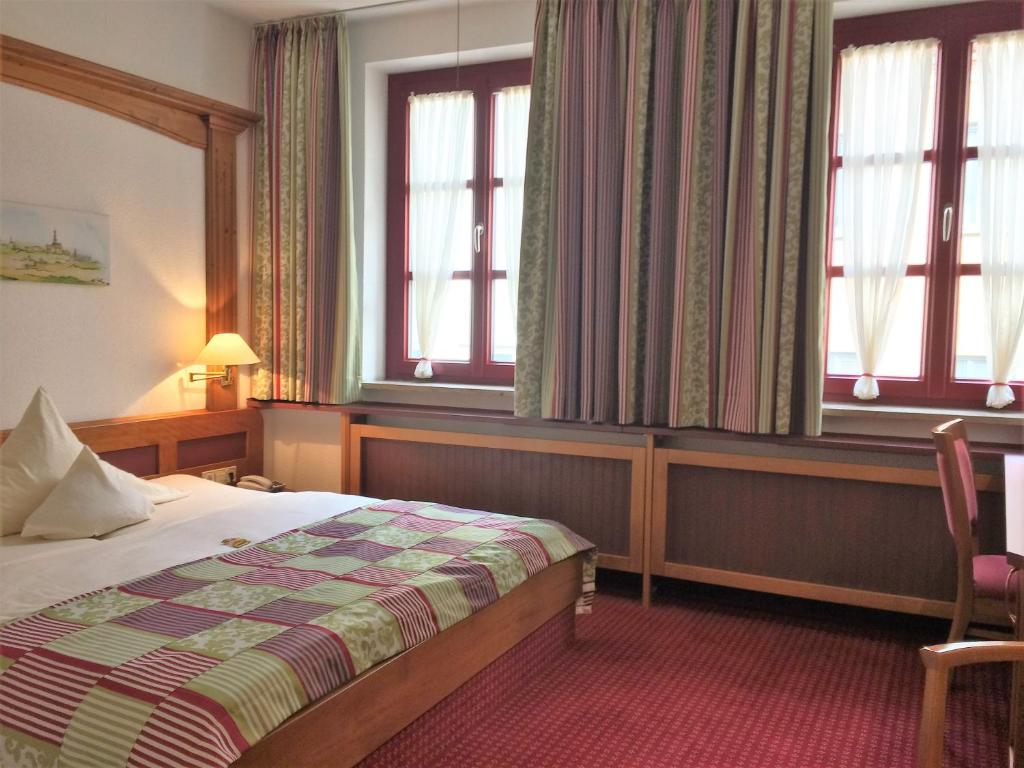 奥格斯堡奥格斯堡霍夫酒店的酒店客房设有一张床和两个窗户。