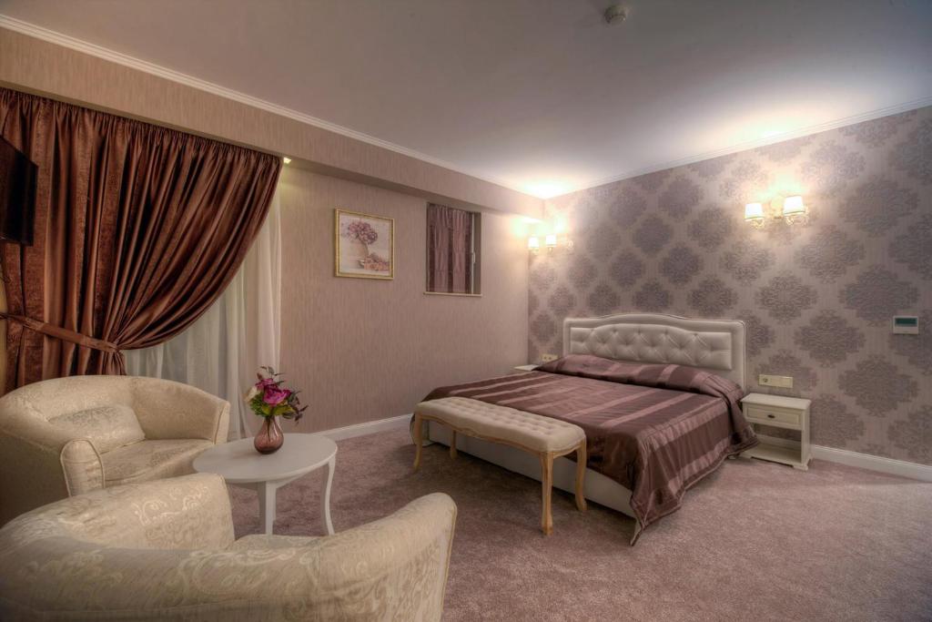 索非亚Family Hotel Agoncev的一间卧室配有一张床、一张沙发和一把椅子