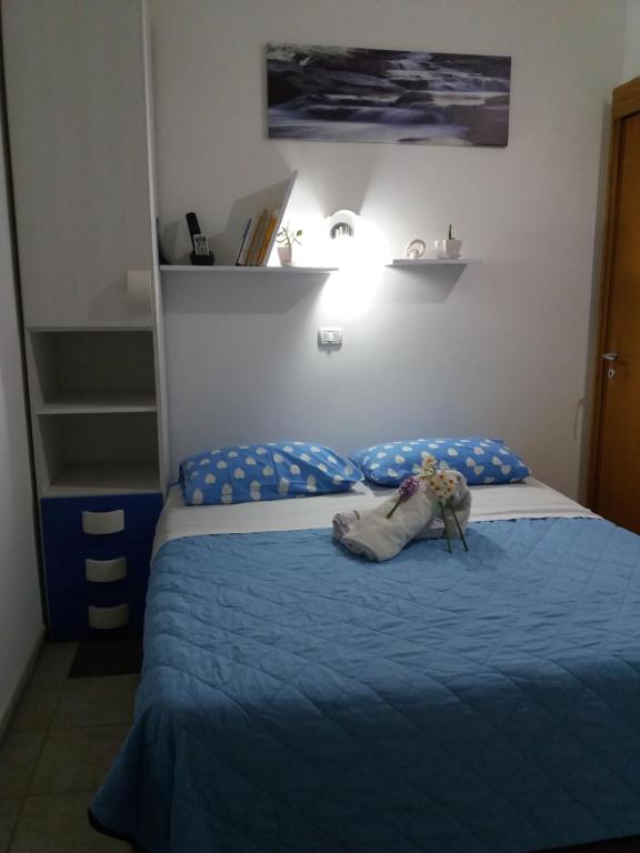切萨雷奥港Casa Delle Rose的一间卧室配有一张带蓝色棉被的床