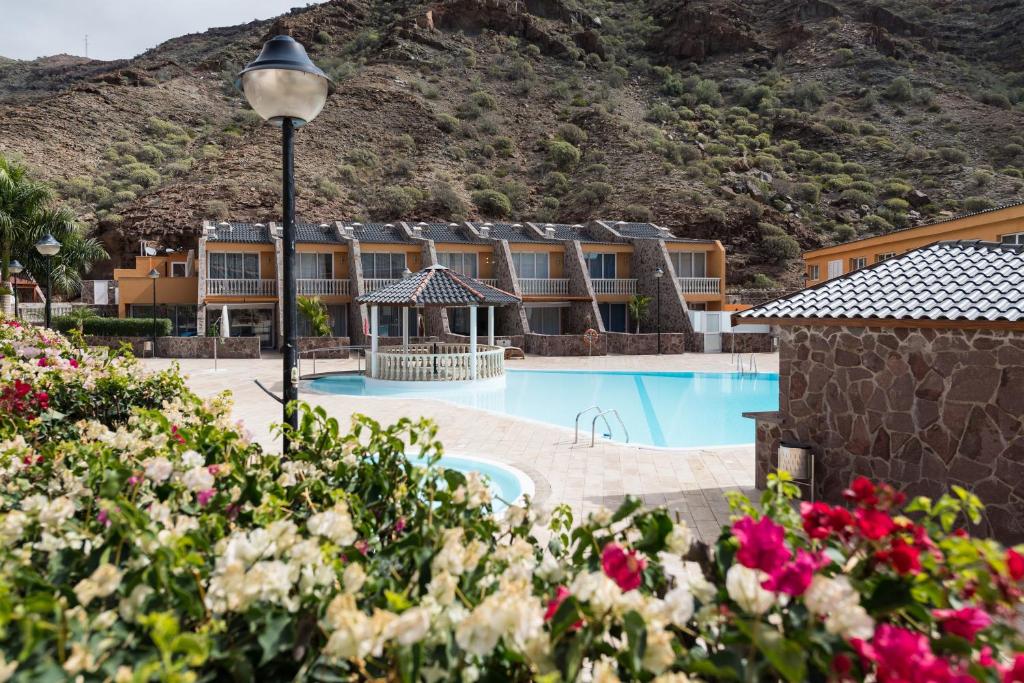 拉普拉亚蒂陶洛Ilusión的一座酒店,拥有一个山地游泳池