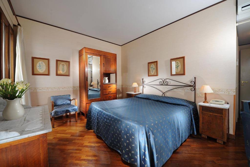威尼斯拉卡尔西纳酒店的一间卧室配有一张带蓝色床罩的床