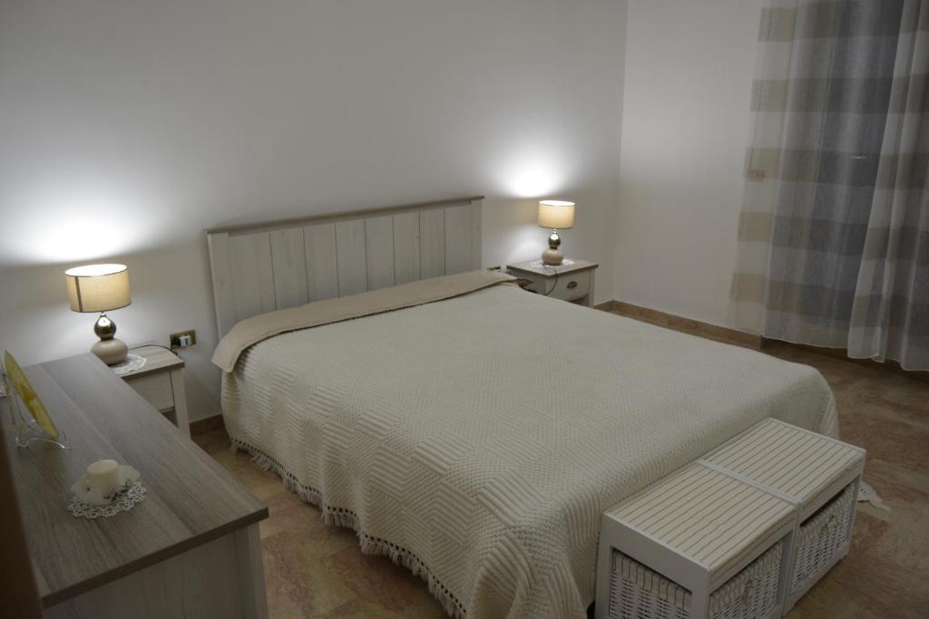 滨海波利尼亚诺Casa Angy的一间卧室配有一张带两张桌子和两盏灯的床。