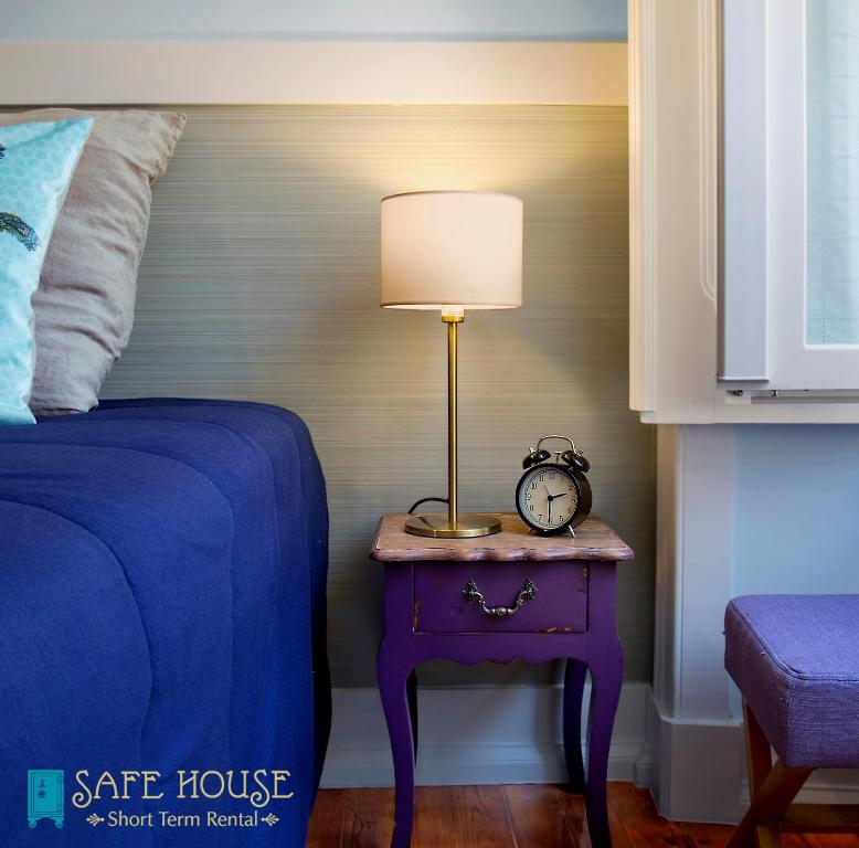 里斯本安全屋公寓的一间卧室配有一张床和一张带台灯的桌子