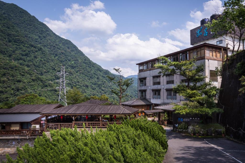 乌来乌来淞吕温泉会馆的酒店建筑背景是一座山