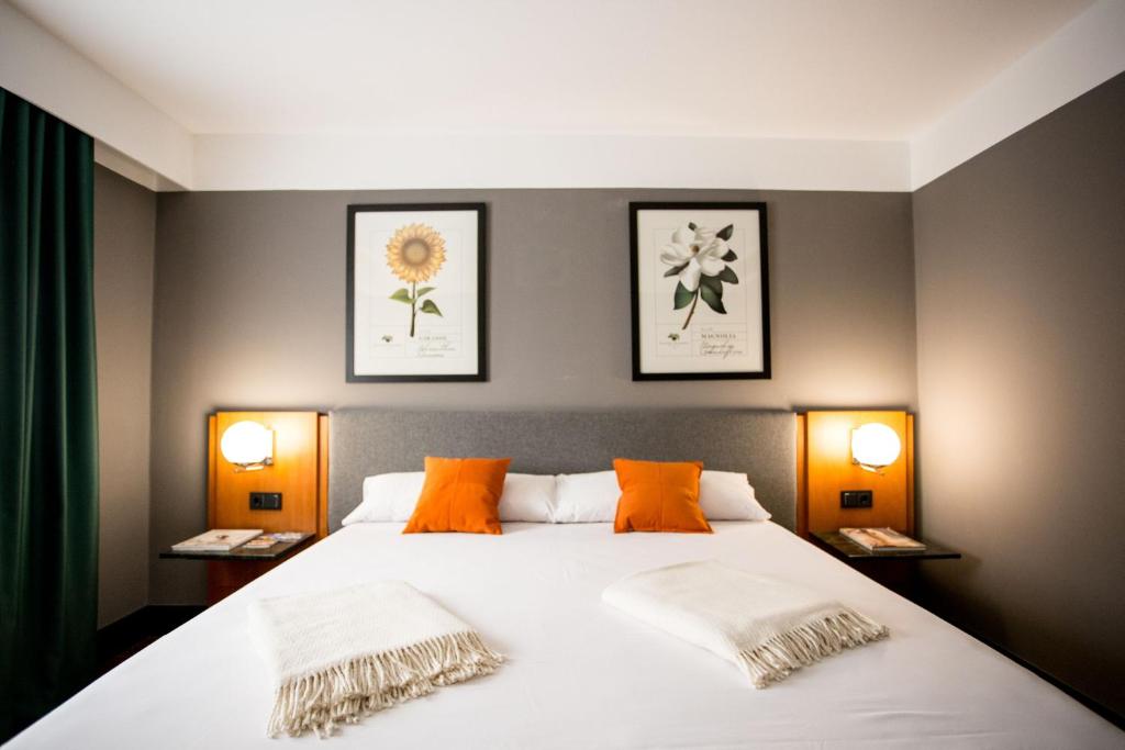 瓦伦西亚马尔科姆和巴瑞特酒店的一间卧室配有一张带两盏灯的大型白色床。