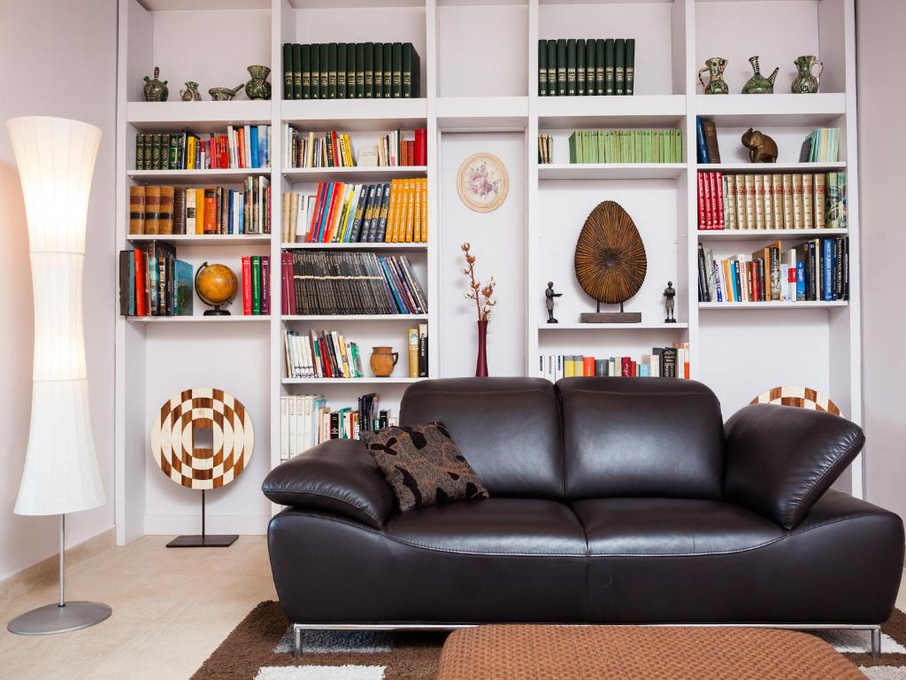 巴塞罗那夸特普利梅拉公寓的客厅里一张黑色皮沙发,配有书架