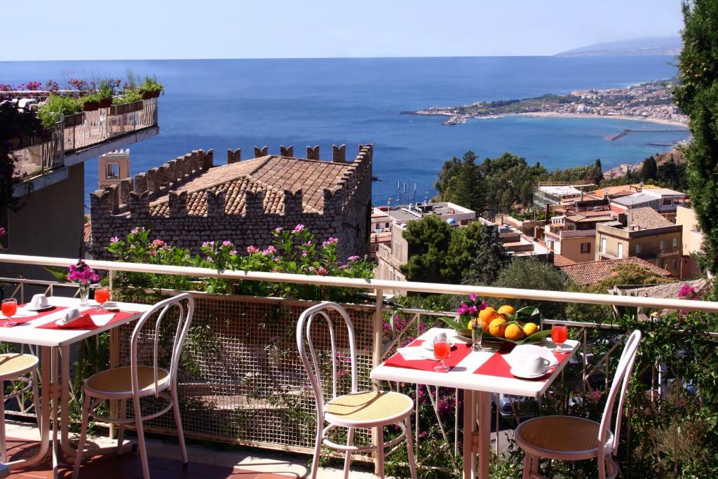 陶尔米纳米迪泰拉尼酒店的阳台配有桌椅,享有海景。