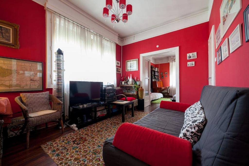 布达佩斯Lonyay Street Apartment的红色的客厅配有沙发和电视