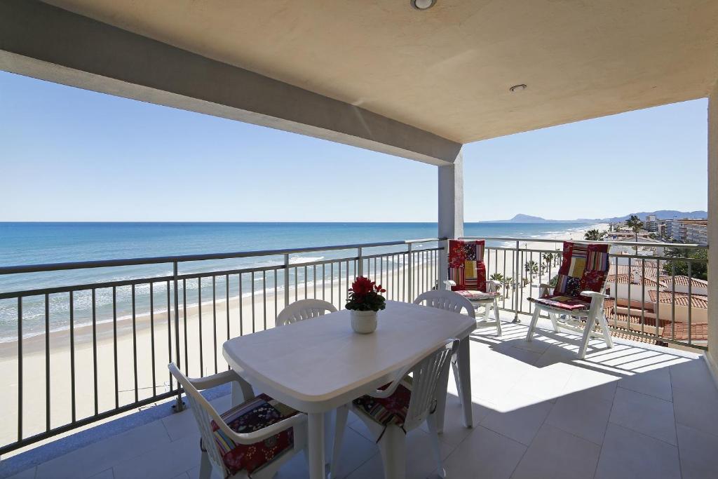贝利雷瓜尔德Apartamento frente al mar的海滩阳台的白色桌椅