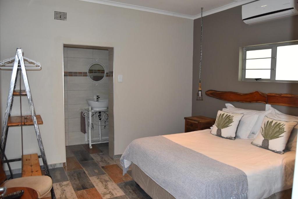基特曼斯胡普Quiver Inn Guesthouse的一间带大床的卧室和一间浴室