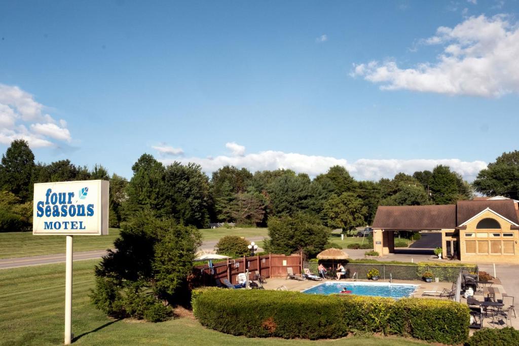 Mount VernonFour Seasons Lodging的一座带游泳池和大楼的度假村的标志