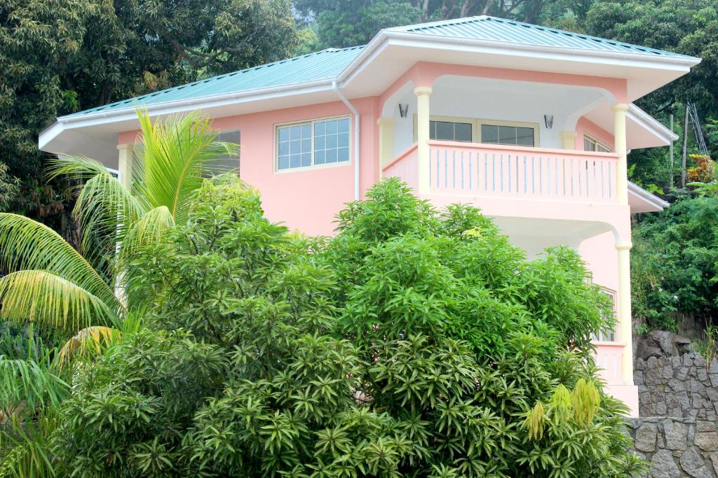 博瓦隆Korrine's Cottage HORIZON的前面有树木的粉红色房子