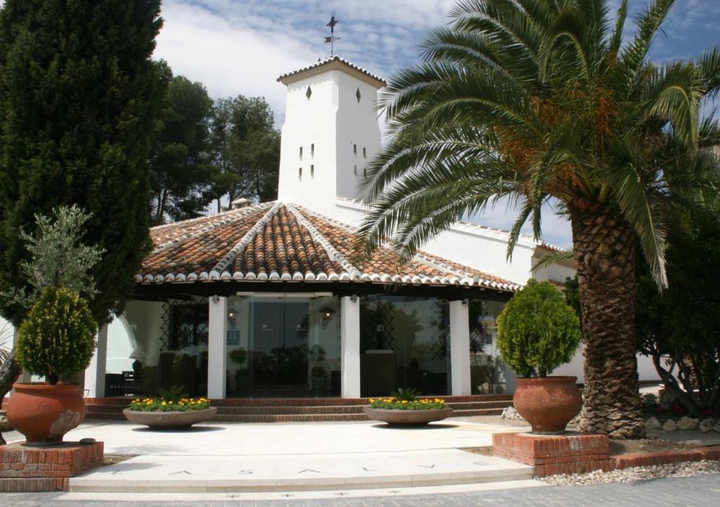 托里霍斯拉撒尔夫酒店加Spa的一座教堂,有白色的塔和棕榈树