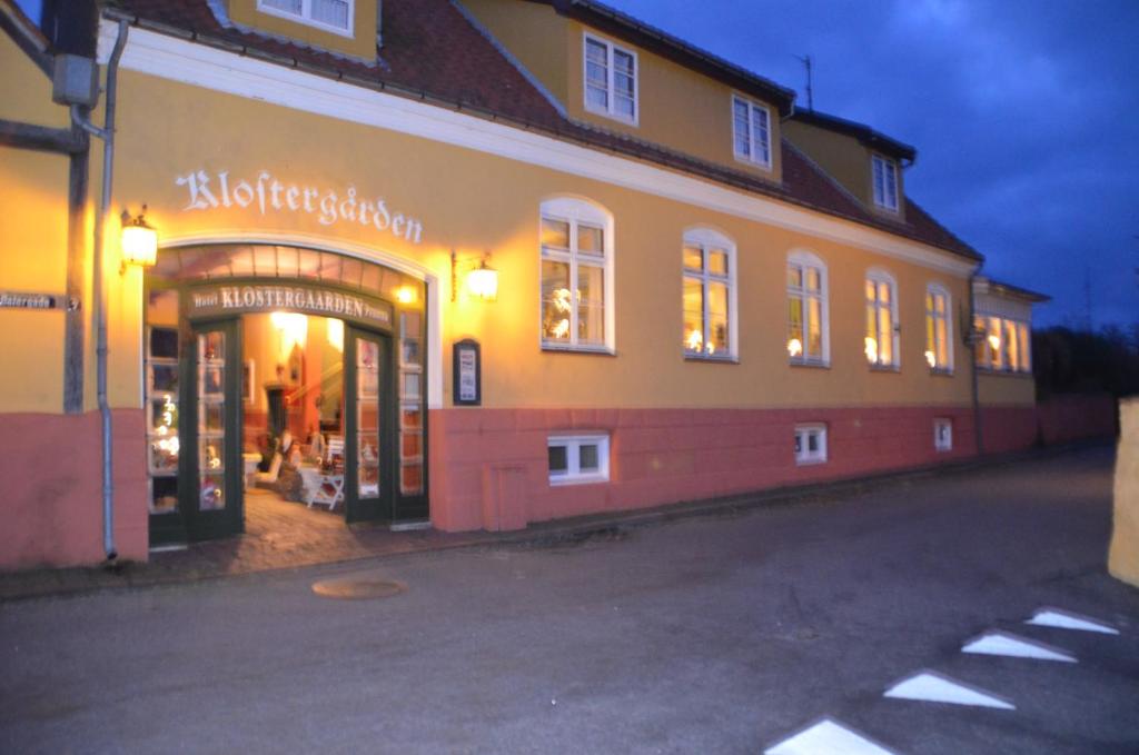 阿灵厄Hotel Klostergaarden的建筑前方的商店,窗户上有灯
