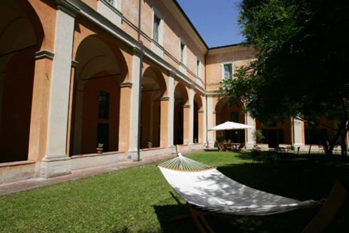 雷焦艾米利亚德拉吉亚拉学生宿舍旅馆的坐在大楼前的草上的一个吊床
