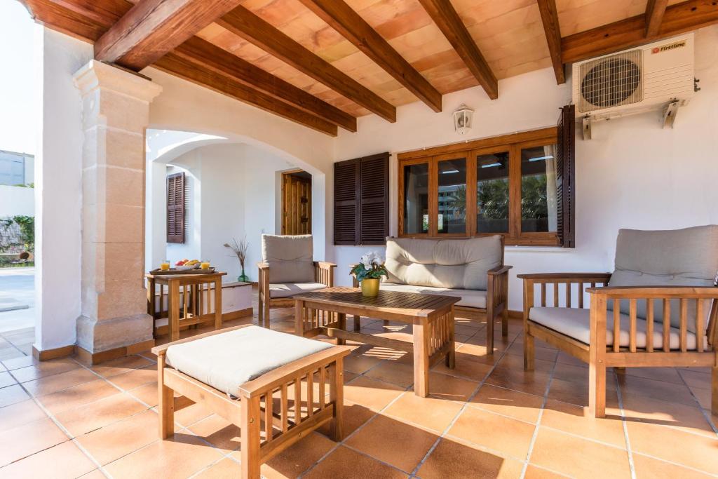 阿尔库迪亚港Chalet Falcó with Private Pool and Garden的庭院设有桌椅和木制天花板。