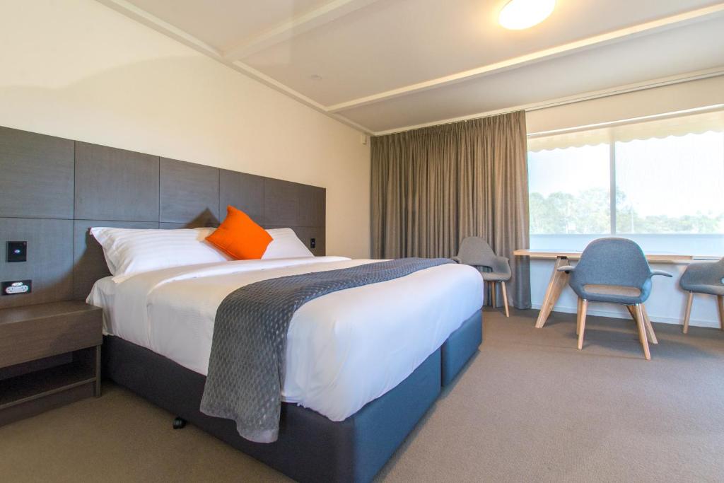 Hackham米克奥西斯酒店的酒店客房设有一张大床和一张书桌。