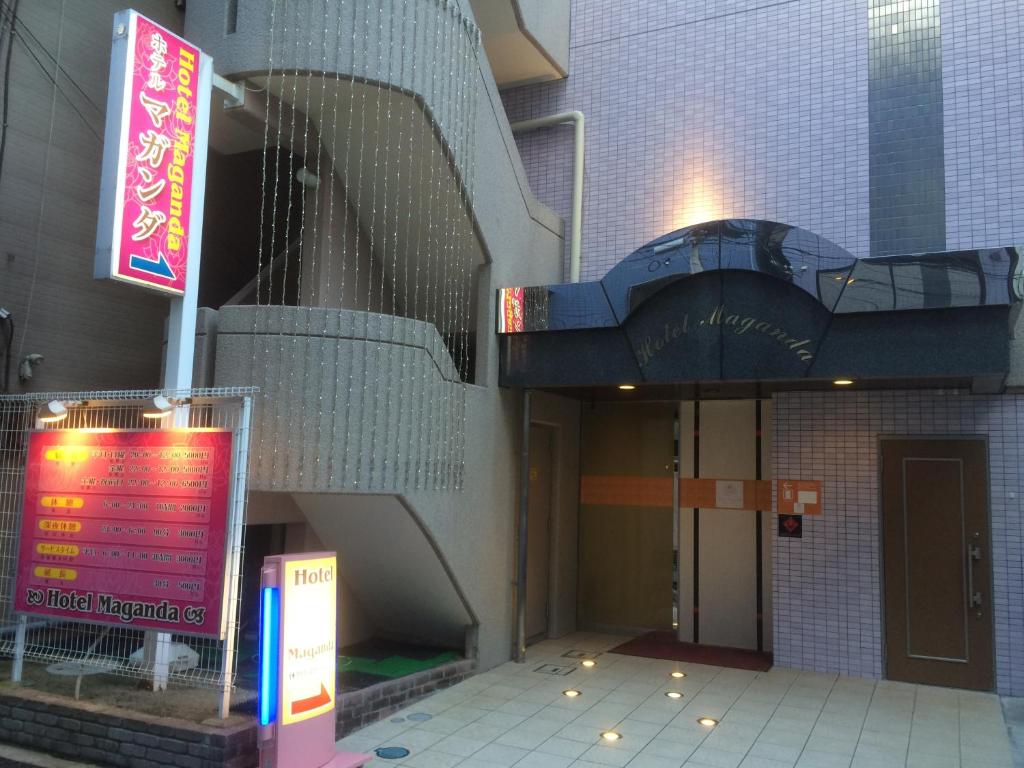 大阪马加达酒店（仅限成人）的一座有楼梯的建筑,前面有标志