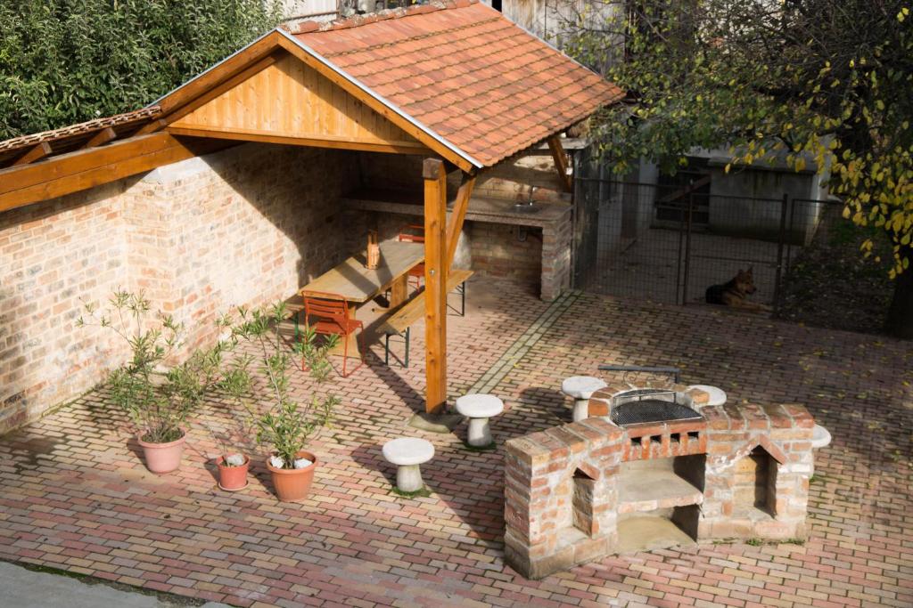 维拉尼Tompos Vendégház és pince的砖砌庭院设有壁炉和木屋顶。