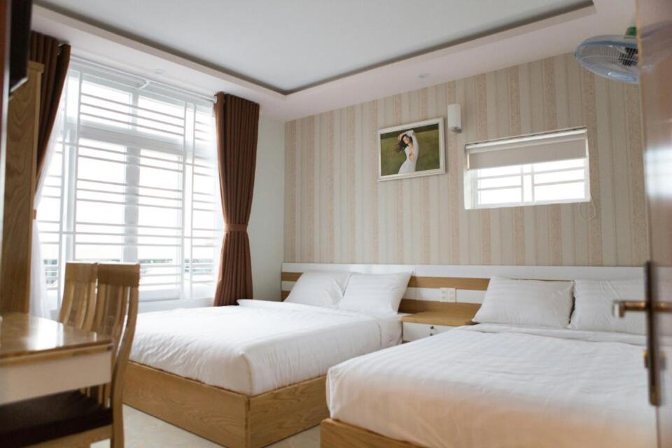 邦美蜀添雅酒店的一间卧室设有两张床、一张桌子和一个窗口