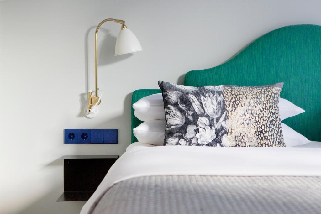 杜塞尔多夫弗里茨杜塞尔多夫国王大道酒店的一间卧室配有一张带绿色床头板的床