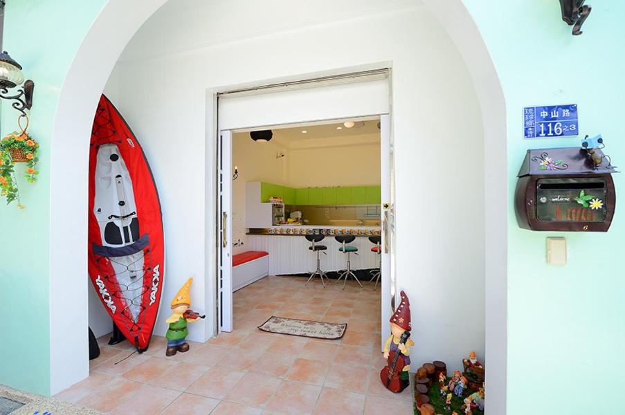 小琉球岛跳跳包棟民宿的客厅设有冲浪板和电视。