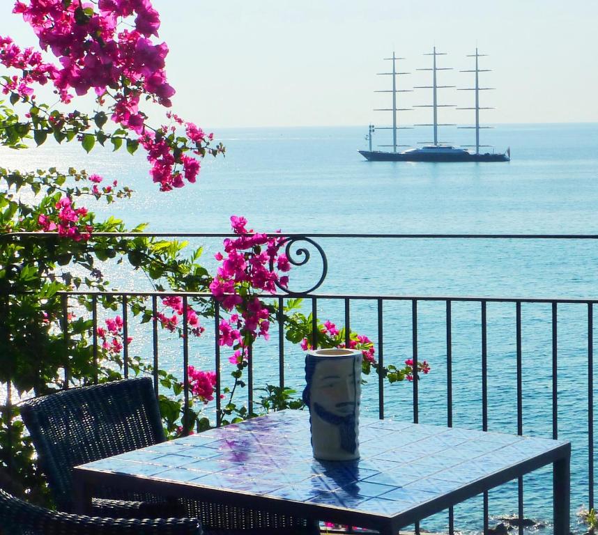 贾迪尼-纳克索斯帕拉迪奥酒店的船上的阳台上的桌子和杯子