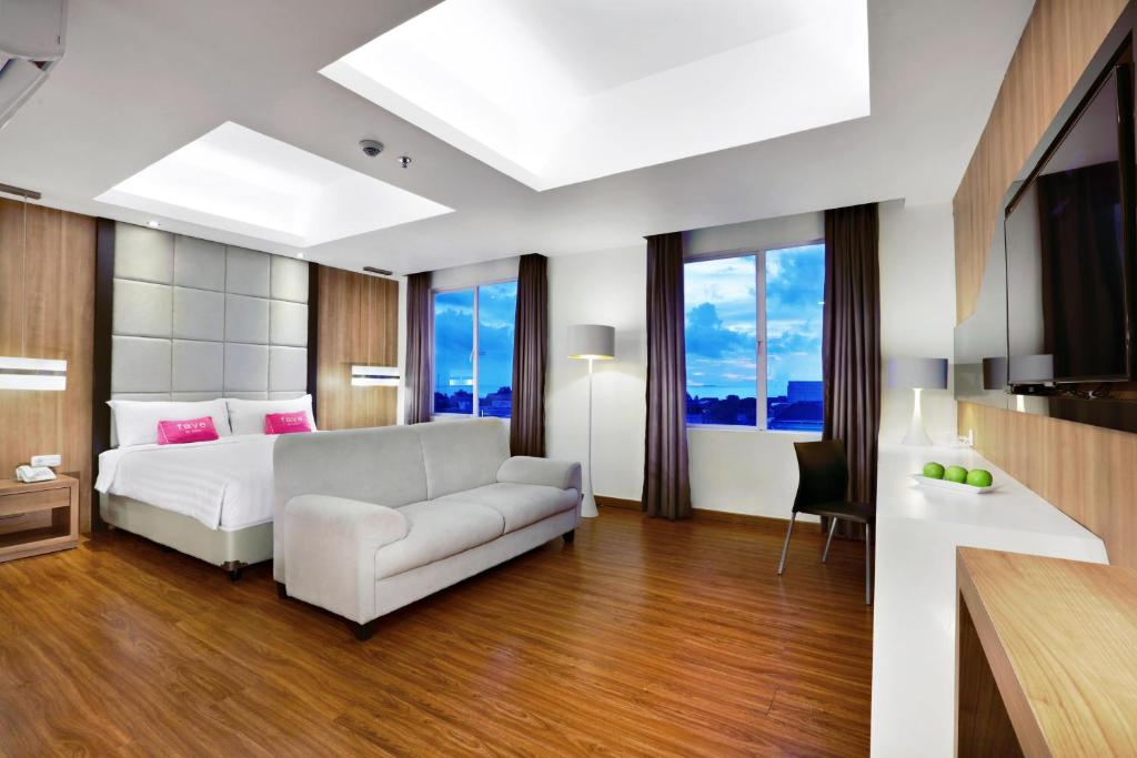 巴东奥罗巴东酒店的卧室配有白色的床和沙发