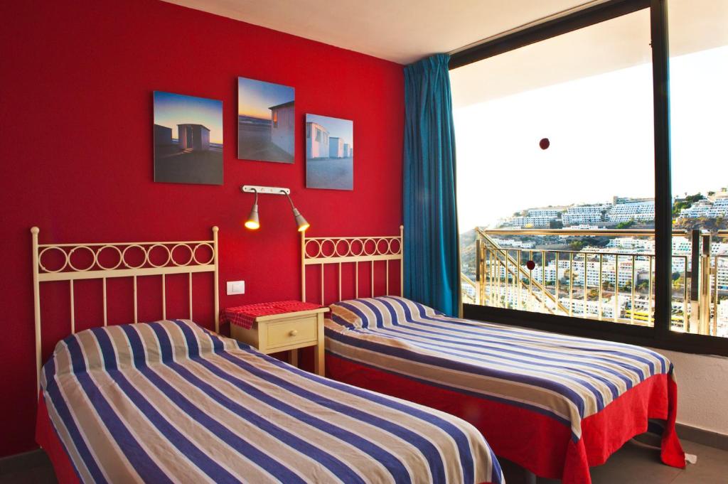 波多黎各米丽亚公寓酒店的红色墙壁客房的两张床