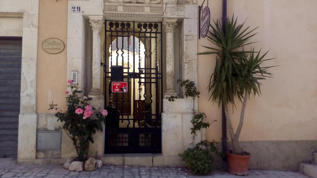 伊斯皮卡艾连霍斯住宿加早餐旅馆的一座带鲜花的黑色门的建筑的入口