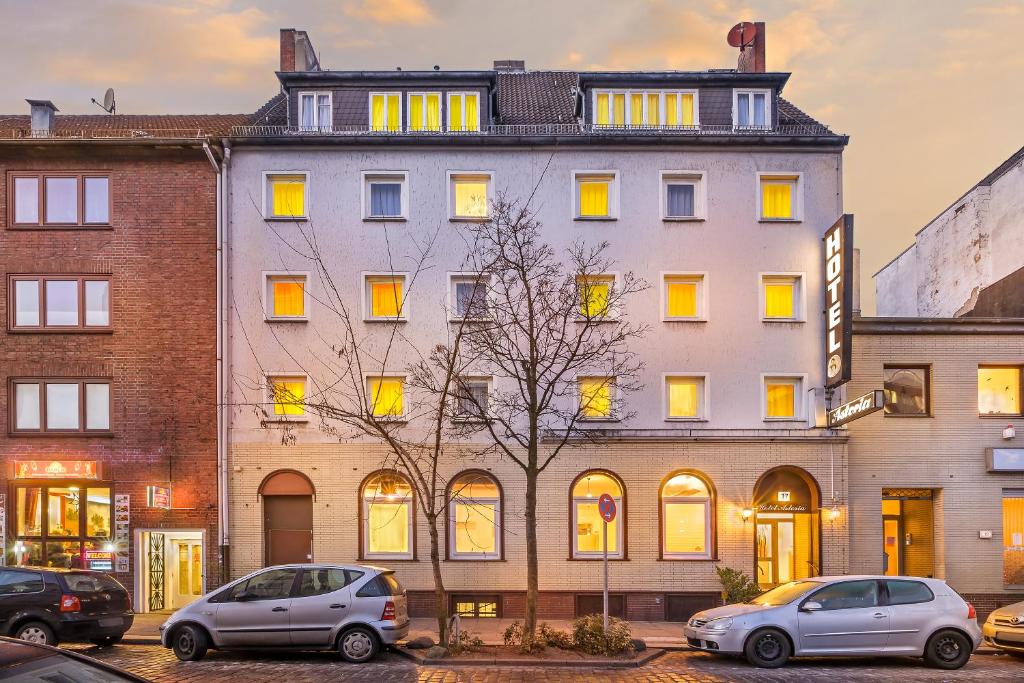 汉堡阿斯托里亚招牌酒店的一座白色的大建筑,前面有汽车停放