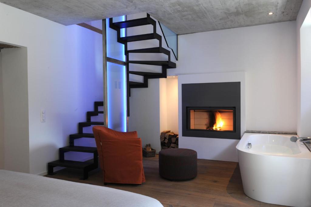 BrioneMyVerzasca Resort Casa Rossa的客房设有螺旋楼梯和壁炉。